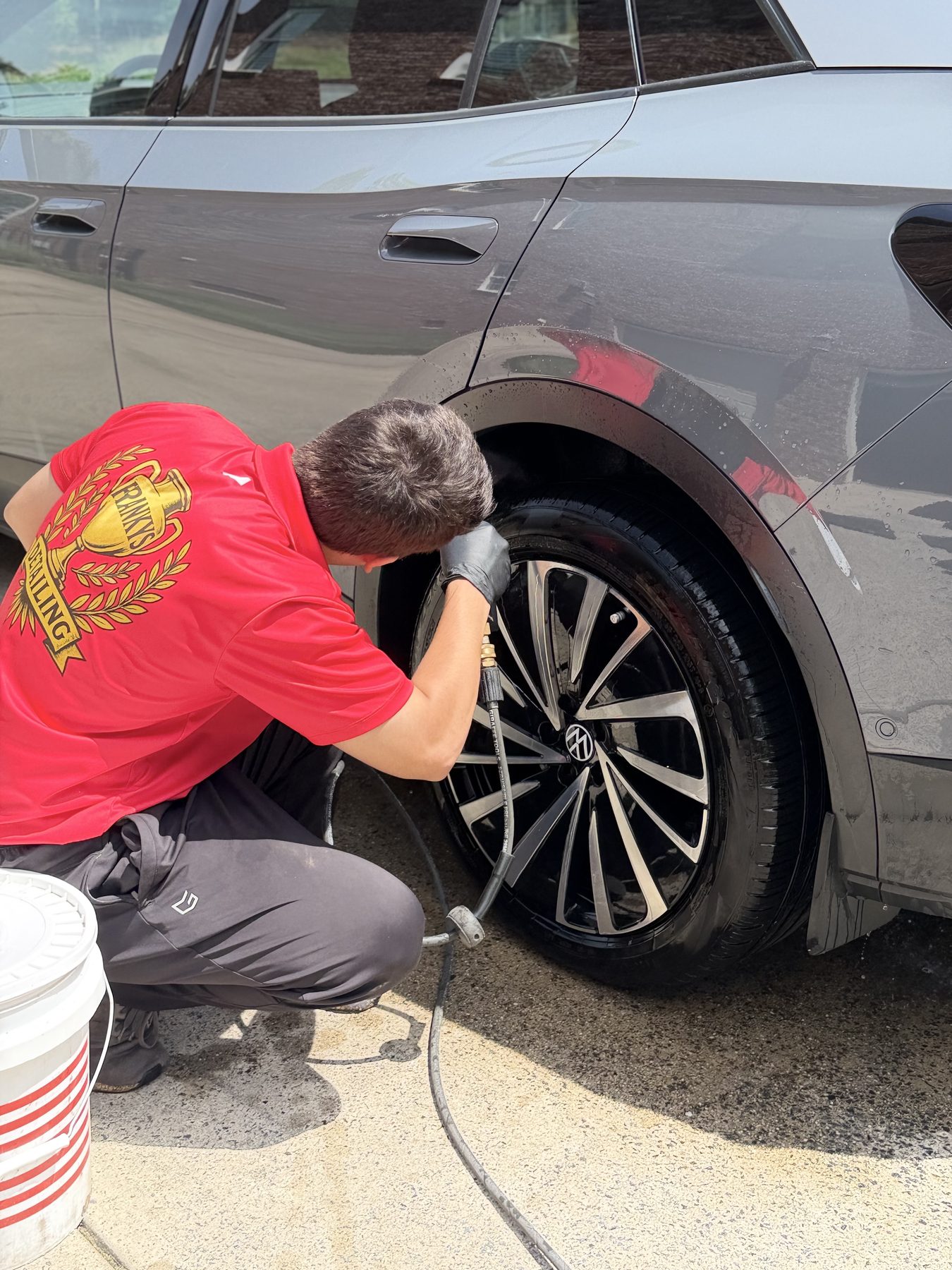 Wheel cleaning detail mid-pass during a full detail service