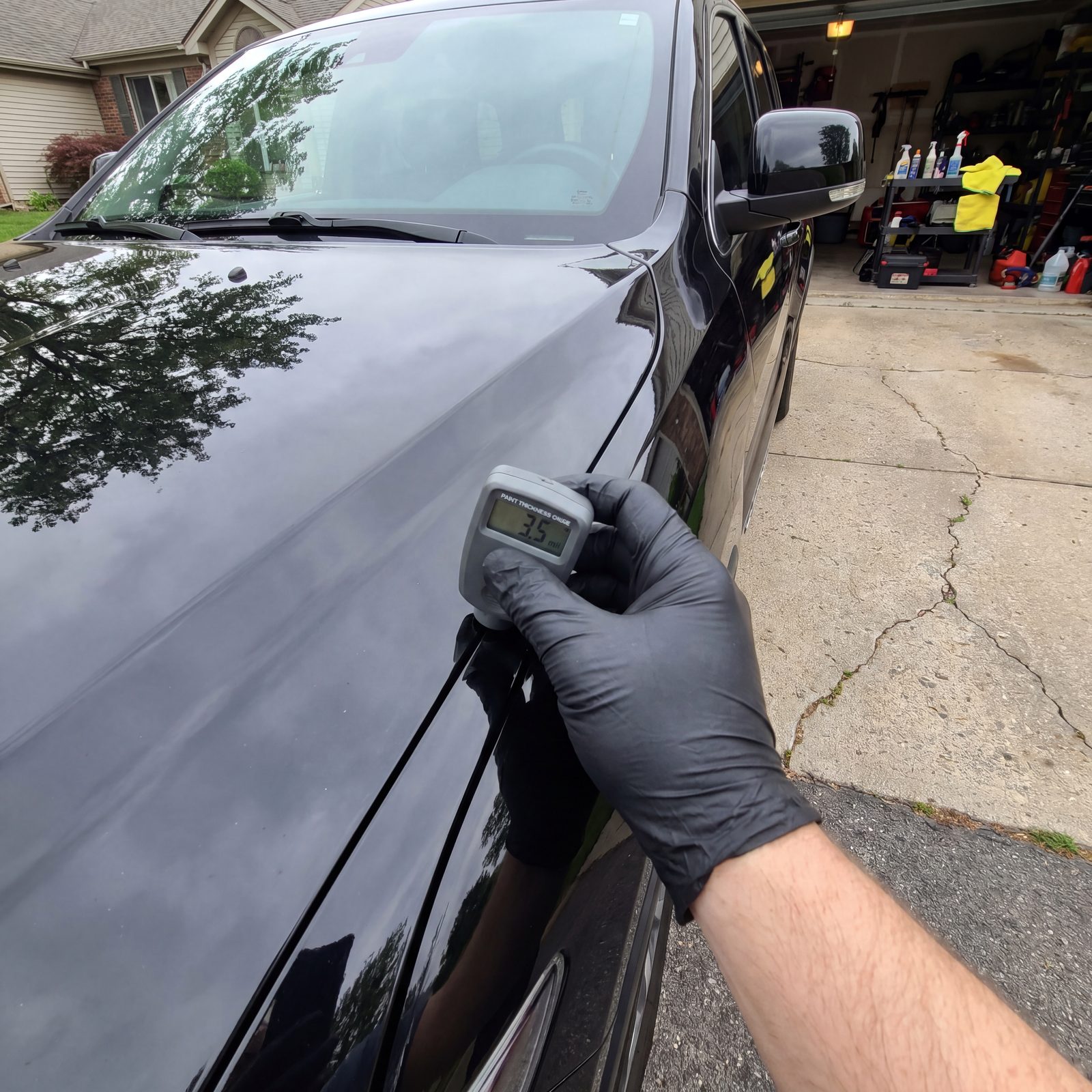 Paint depth gauge being used to measure clear-coat thickness before paint correction